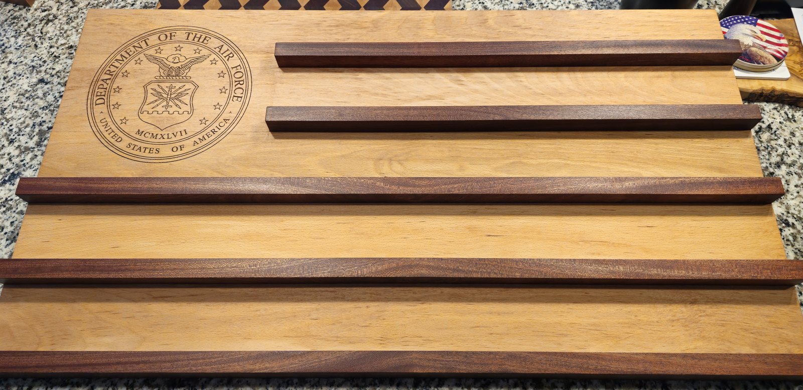 Challenge coin flag display with the Department of the Air Force seal engraved into a beech panel and mahogany stripe rails